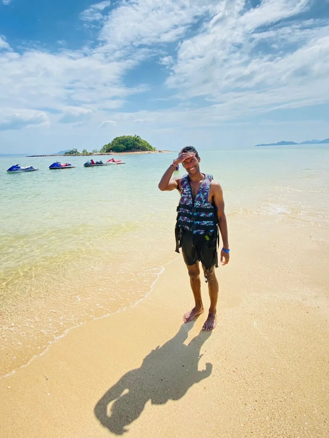 Sai on a beach in a blue shirt