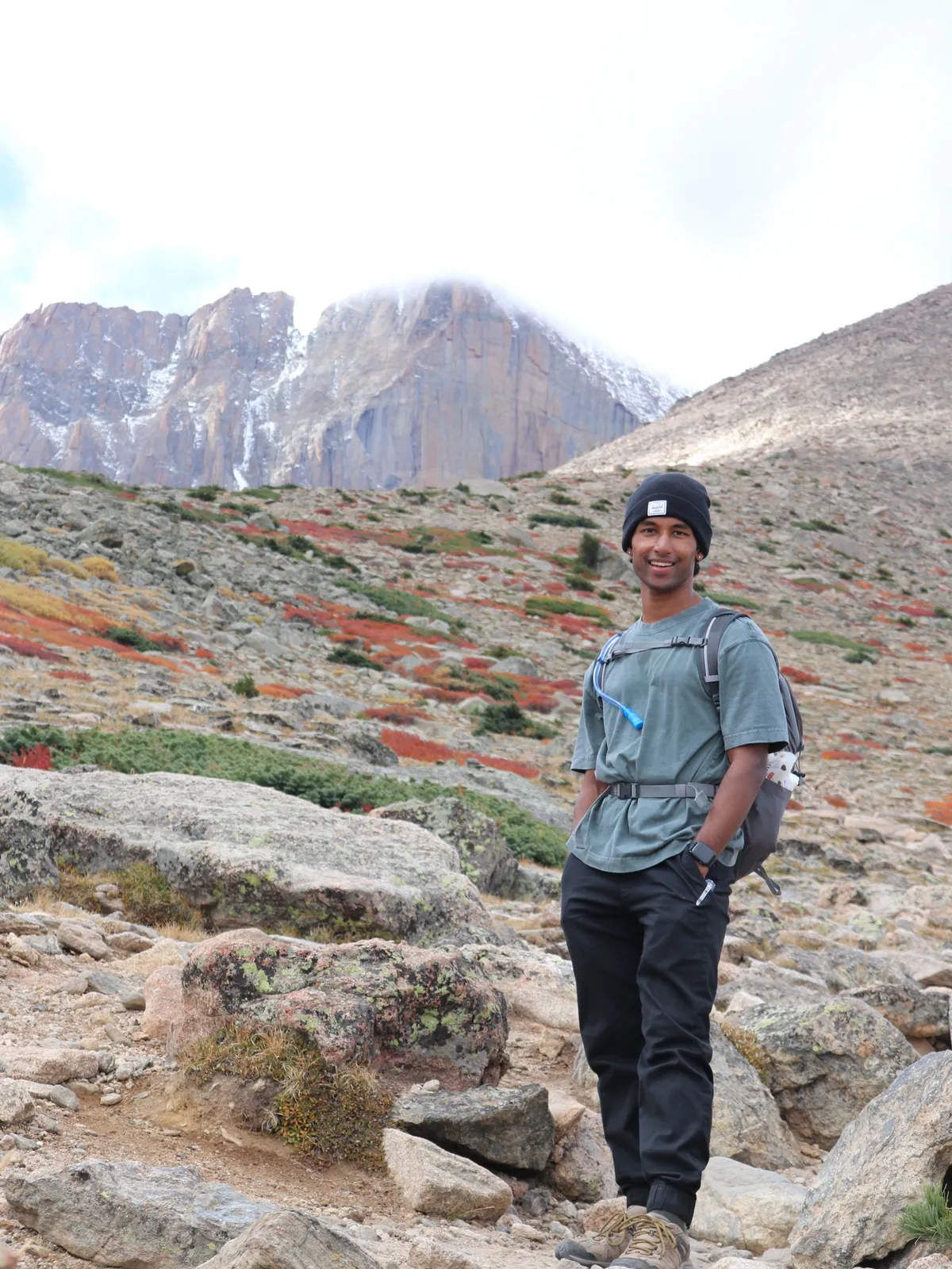 Sai on a mountainside in a teal shirt